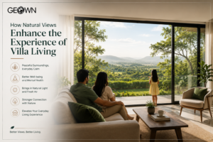 Modern luxury villa living room with floor-to-ceiling glass windows overlooking lush greenery, hills, and scenic landscapes, as an Indian family enjoys the peaceful natural views, highlighting how nature enhances comfort, well-being, and the villa living experience.