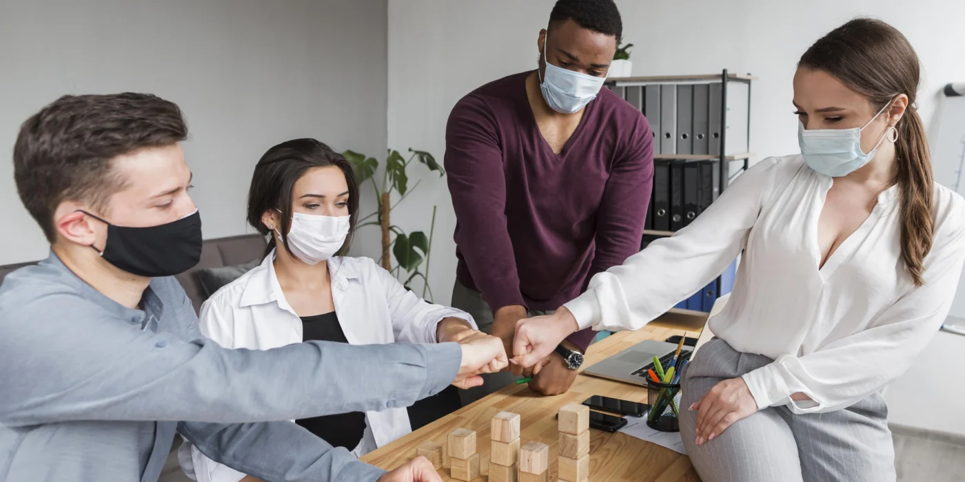 people-office-pandemic-having-meeting-fist-bumping-each-other