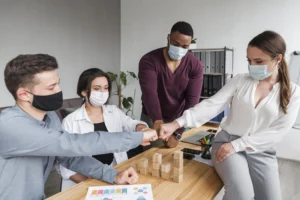 people-office-pandemic-having-meeting-fist-bumping-each-other