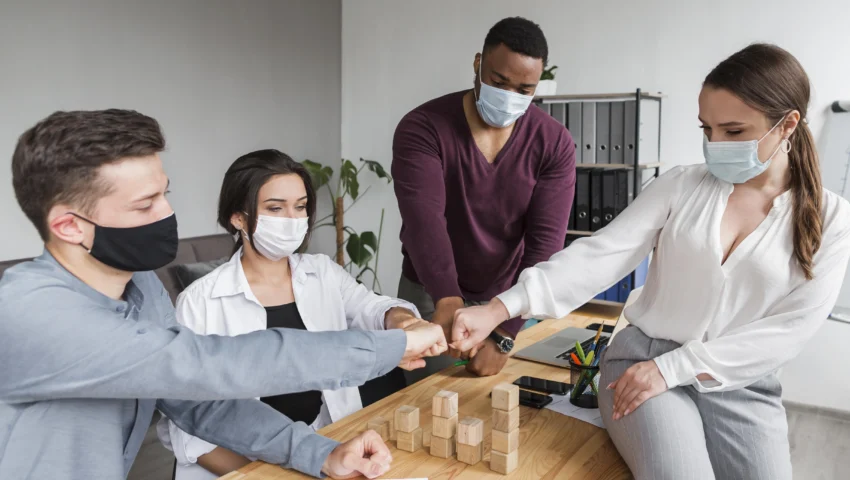 people-office-pandemic-having-meeting-fist-bumping-each-other